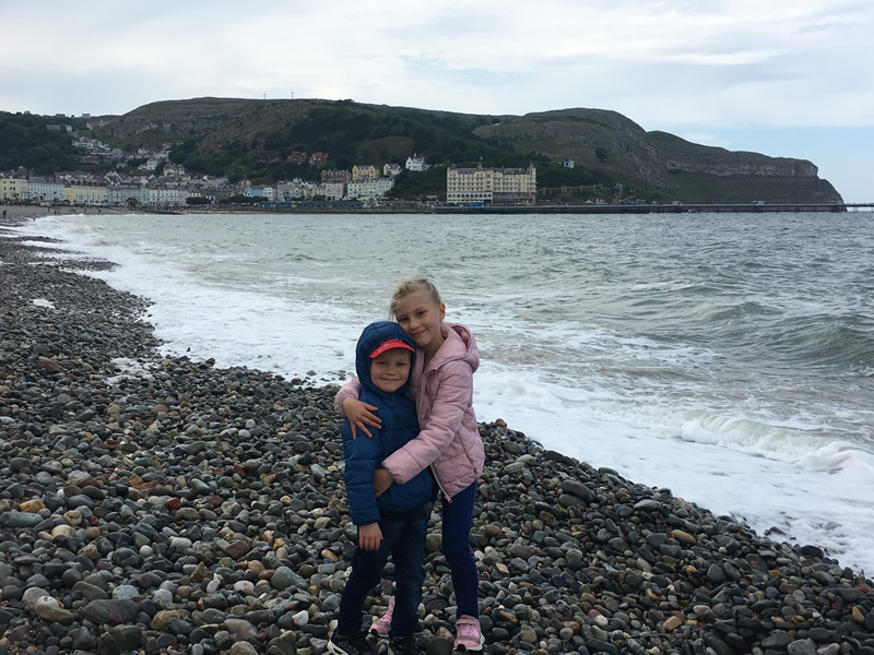 Two children standing on Llandudno beach.