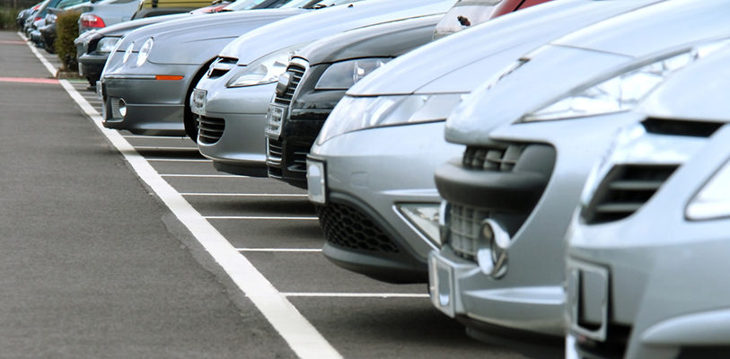 Row of cars parked in parking bays on a busy day