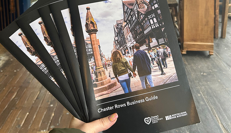 Hand holding five Chester Rows Business Guides