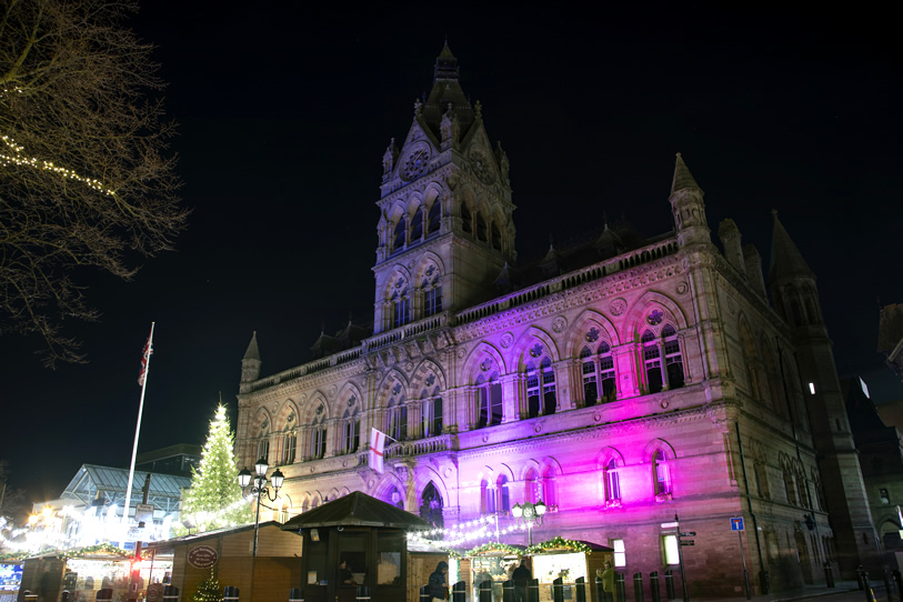 Chester Town Hall lit up for Christmas with the Christmas Markets in the foreground.