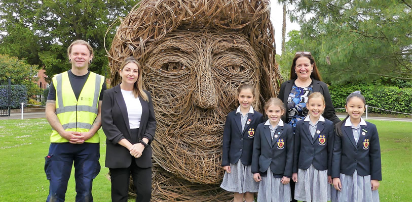 StreetCare Officer, Phil Hutchinson; Environment Development Officer, Rebecca Irving; Head of the Queen's Lower School, Iona Carmody and pupils from the school, with the sculpture.