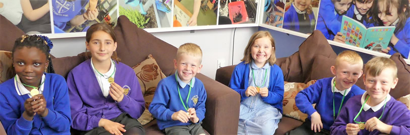 Children holding medals from the Summer Reading Challenge