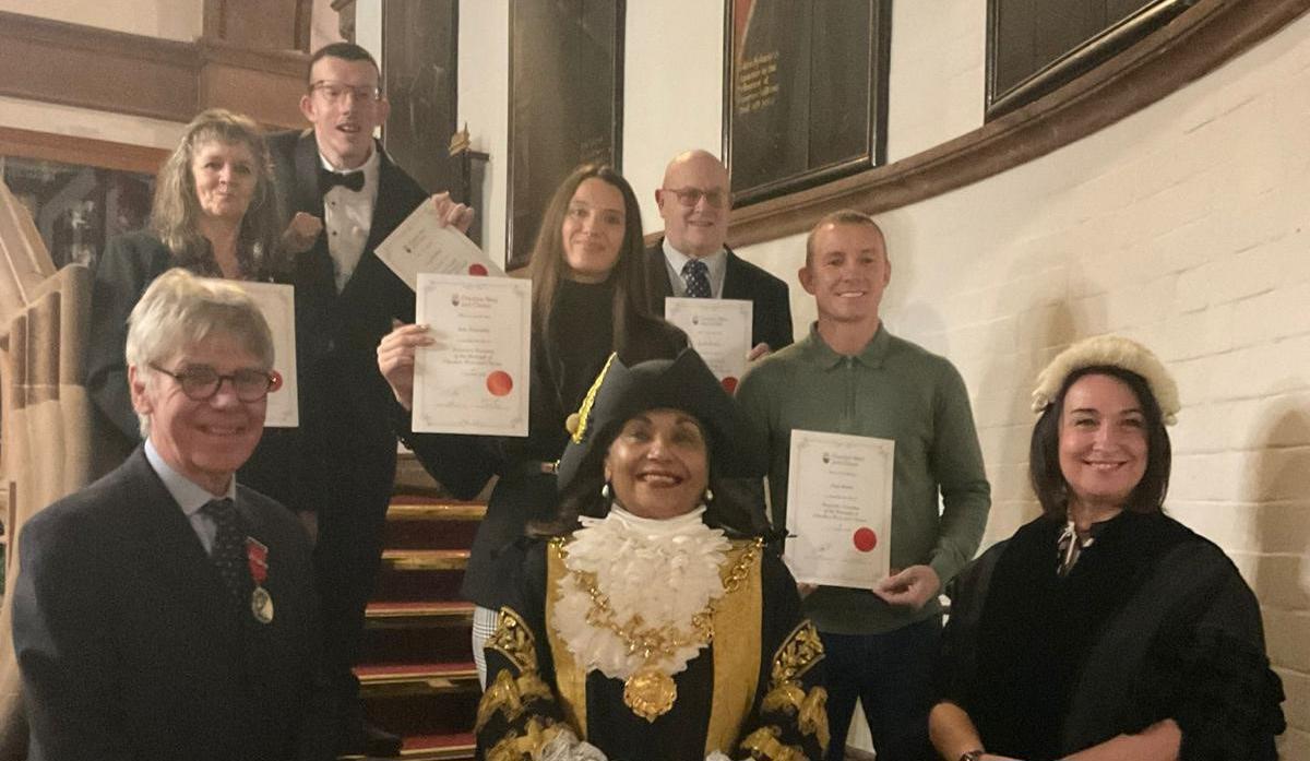 Group of people with certificates stand with Lord Mayor of Chester